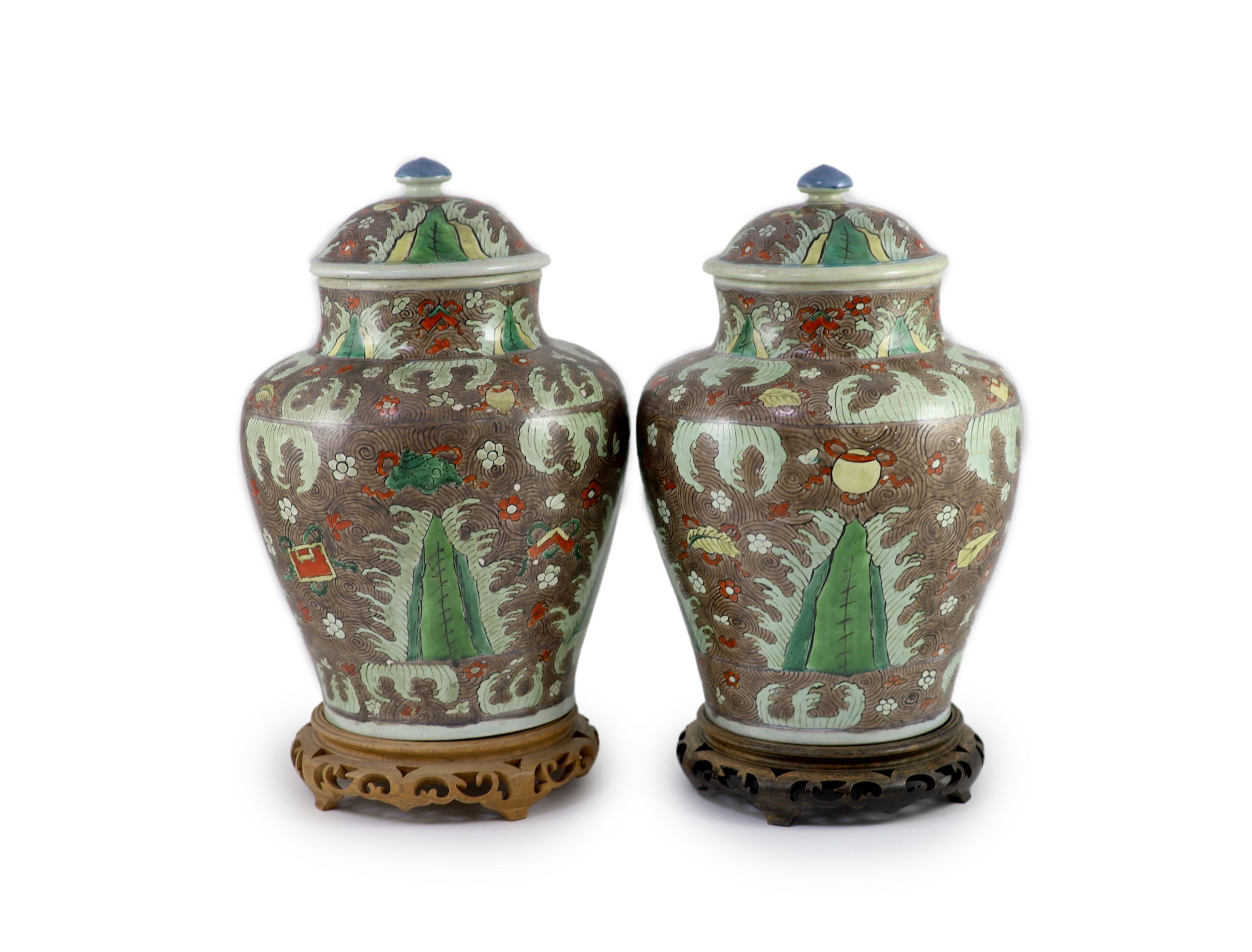 A pair of Chinese enamelled porcelain jars and covers, in Transitional style, 34cm high, wood stands